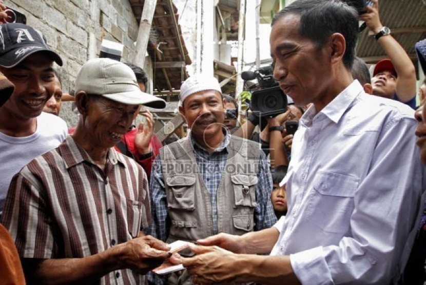  Gubernur DKI Jakarta, Joko Widodo membagikan Kartu Jakarta Sehat kepada penduduk kelurahan Marunda di Jakarta Utara, Senin (12/11). (Adhi Wicaksono)