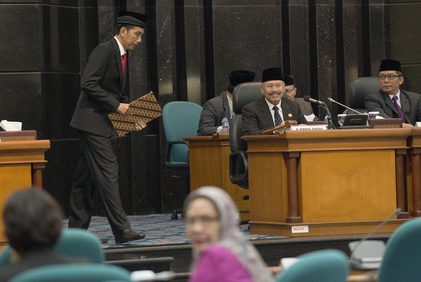 Gubernur DKI Jakarta yang juga Presiden terpilih, Joko Widodo (kiri) berjalan di dekat Ketua DPRD DKI Jakarta Ferrial Sofyan (tengah) dan Wakil Ketua Boy Sadikin (kanan) menuju podium untuk memberikan pendapat akhir pada Rapat Paripurna DPRD DKI Jakarta di