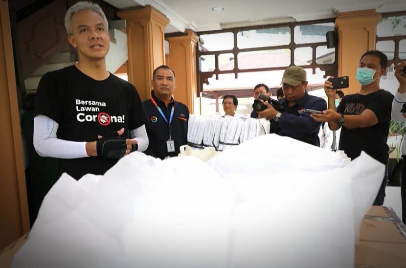 Gubernur Ganjar Pranowo menunjukkan bahan serta pakaian Alat Pelindung Diri (APD) 