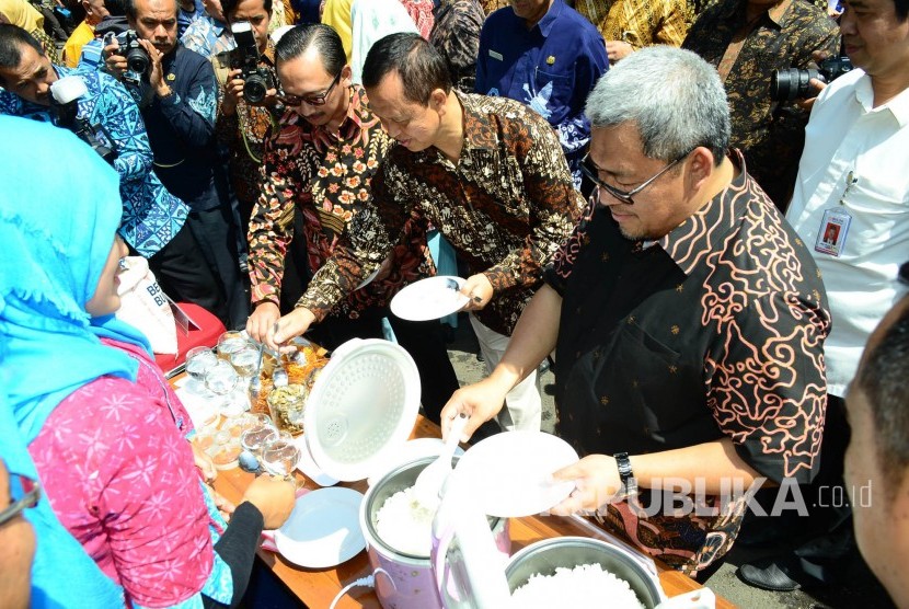 Gubernur Jabar Ahmad Heryawan bersama para pejabat lain mencoba nasi dari beras raskin atau beras sejahtera (Rastra) pada acara 