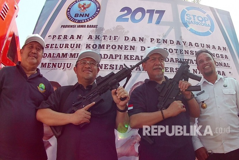 Gubernur Jabar Ahmad Heryawan dan Wakil Gubernur Deddy Mizwar memegang senapan sebagai simbol perang terhadap narkotika pada puncak Peringatan Hari Narkotika Internasional, di Komplek Gedung Sate, Kota Bandung, Senin (24/7).