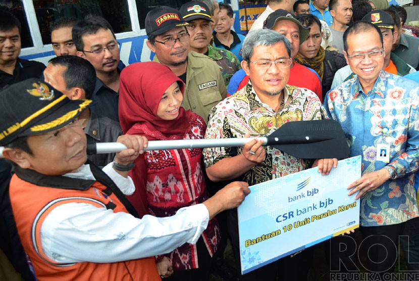   Gubernur Jabar Ahmad Heryawan (kedua kanan), dengan Wakil Bupati Bandung Deden Rumaji (kiri), dan Dirut Bank Bjb Ahmad Irfan (kanan), pada penyerahan bantuan sepuluh perahu karet CSR Bak BJB, di Perempatan Jl Raya Bojongsoang (Ilustrasi)