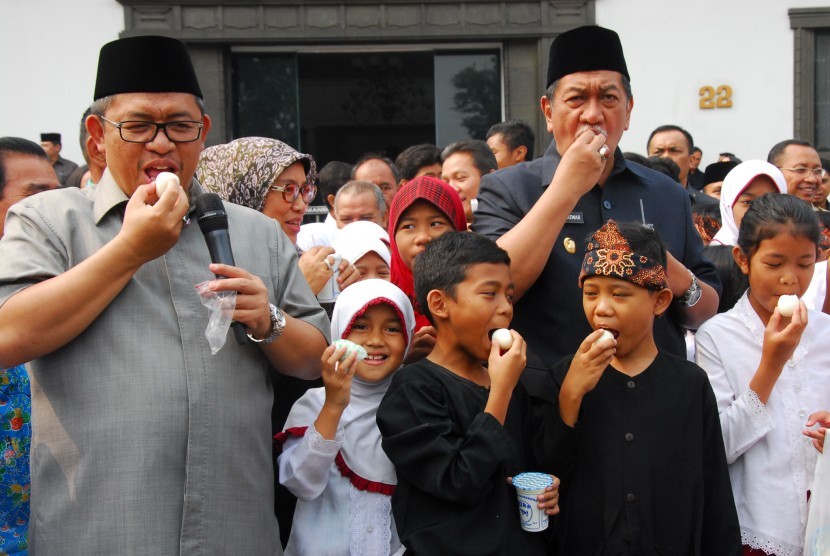 Gubernur Jabar Ahmad Heryawan (kiri) dan Wagub Dedy Mizwar (kanan) bersama para pelajar mengonsumsi telur dan susu dalam perayaan Hari Pangan se-Dunia di pelataran Gedung Sate Bandung, Jawa Barat, Rabu (7/10). 