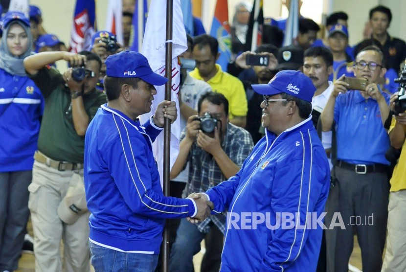 Gubernur Jabar Ahmad Heryawan melakukan simbolis memberikan bendera koni pada peresmian melepas kontingen Jawa Barat saat apel besar kebuletan tekad kontingen Jabar Kahiji di Gor Pajajaran, Kota Bandung, Kamis (7/9). (Mahmud Muhyidin)