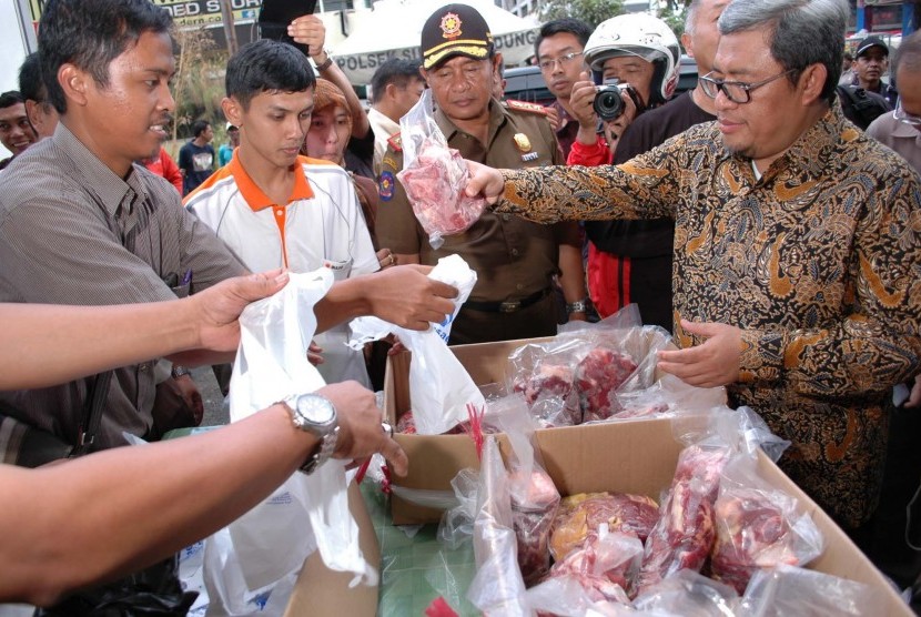 Gubernur Jabar Ahmad Heryawan membeli daging sapi saat meninjau operasi pasar daging sapi, di Pasar Kosambi, Kota Bandung, Rabu (12/8).  