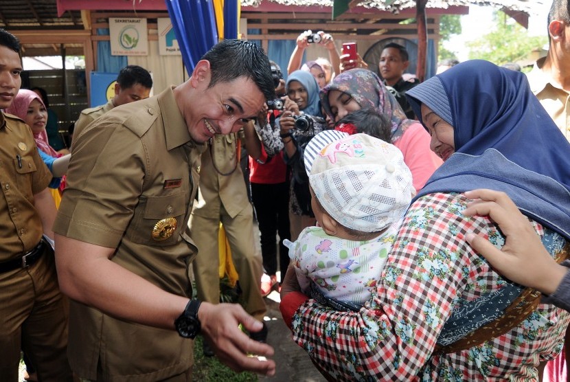 Gubernur Jambi Zumi Zola Zulkifli (kiri) menghibur balita yang akan diimunisasi usai Pencanangan Pekan Imunisasi Nasional (PIN) Polio Provinsi Jambi 2016 di Posyandu Kaswari, Kota Baru, Jambi, Selasa (8/3). 