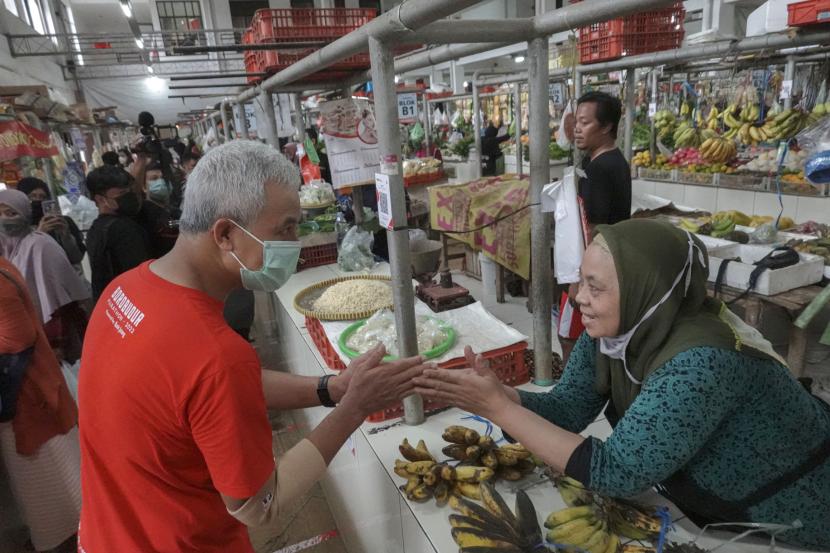 Gubernur Jateng Ganjar Pranowo (kiri) bersalaman dengan pedagang saat blusukan di Pasar Manis Purwokerto, Banyumas, Jateng, Senin (18/7/2022). Ganjar melakukan blusukan di Pasar Manis saat melakukan kunjungan kerja di Kabupaten Banyumas, untuk memantau fluktuasi harga bahan pokok dalam upaya pengendalian inflasi di Jawa Tengah. 