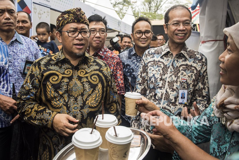 Gubernur Jawa Barat Ahmad Heryawan (kiri) didampingi Direktur Utama Bank BJB Ahmad Irfan (kanan) meninjau stan UMKM binaan saat kegiatan West Java Coffee & Art dan HUT ke-57 Bank BJB di Bandung, Jawa Barat, Jumat (11/5).