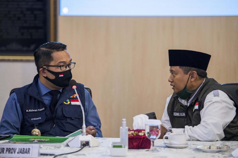 Gubernur Jawa Barat Ridwan Kamil berbincang dengan Wakil Gubernur Uu Ruzhanul Ulum di sela-sela rapat Gugus Tugas Percepatan Penanggulangan COVID-19 di Makodam III Siliwangi, Bandung,