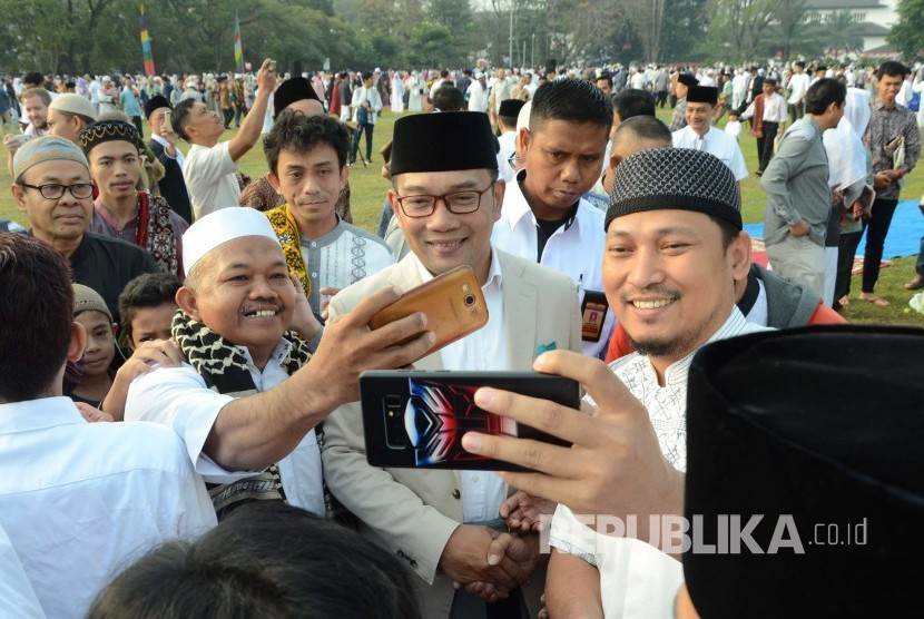 Gubernur Jawa Barat Ridwan Kamil berfoto bersama dengan masyarakat usai shalat Idul Adha 1440 H, di Lapangan Gasibu, Kota Bandung, Ahad (11/8).