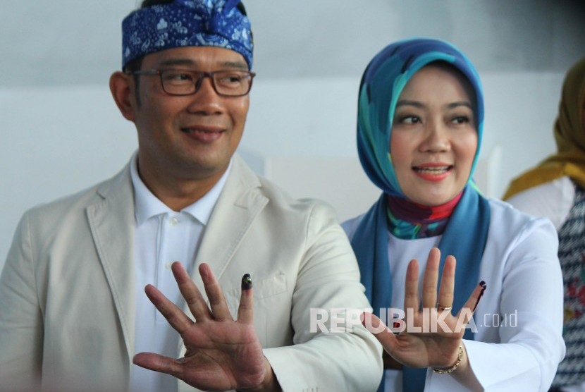 Gubernur Jawa Barat Ridwan Kamil berserta istrinya Atalia Praratya memperlihatkan tinta di jari kelingkingnya usai melakukan pencoblosan Pemilu 2019, di TPS 32, Cigadung, Kota Bandung, Rabu (17/4).