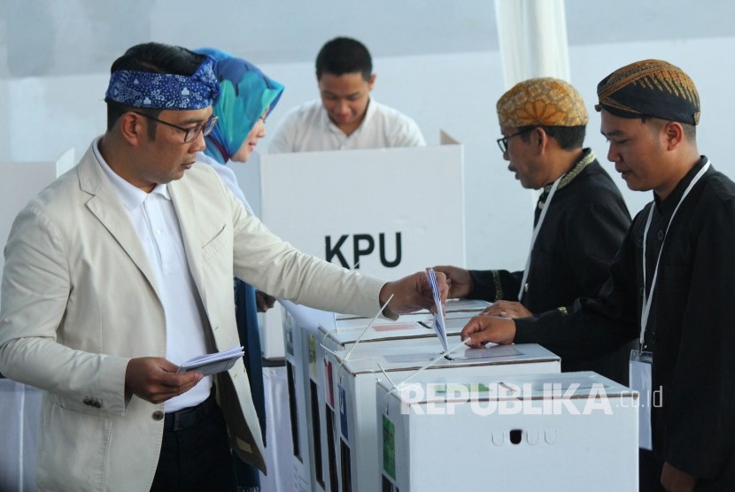 Gubernur Jawa Barat Ridwan Kamil berserta istrinya Atalia Praratya memasikan surat suara usai melakukan pencoblosan Pemilu 2019, di TPS 32, Cigadung, Kota Bandung, Rabu (17/4).