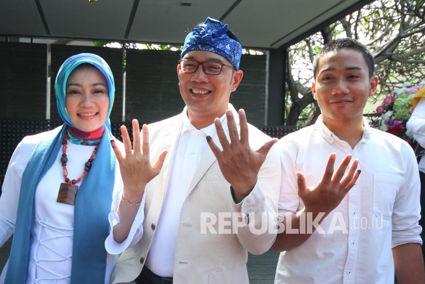 Gubernur Jawa Barat Ridwan Kamil berserta istrinya Atalia Praratya dan anaknya Emmiril Khan Mumtaz memperlihatkan tinta di jari kelingkingnya usai melakukan pencoblosan Pemilu 2019, di TPS 32, Cigadung, Kota Bandung, Rabu (17/4).