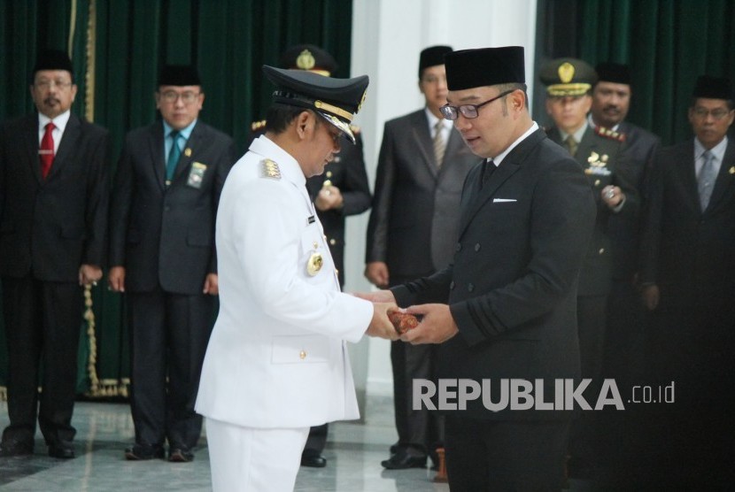 Gubernur Jawa Barat Ridwan Kamil (kanan) melantik Eka Supria Atmaja sebagai Bupati Bekasi definitif yang baru dilantik, di Aula Barat, Gedung Sate, Kota Bandung, Rabu (12/6).