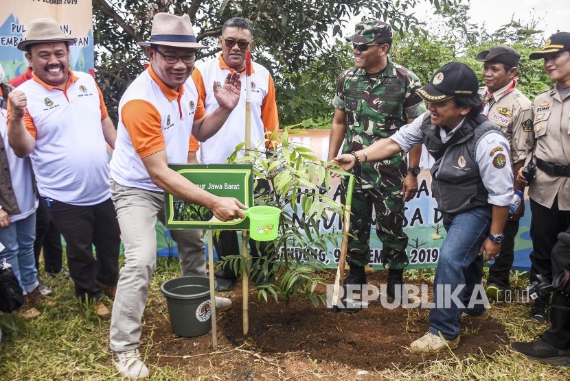 Gubernur Jawa Barat Ridwan Kamil (kedua kanan) menanam pohon secara simbolis di area perkebunan di Kawasan Bandung Utara (KBU), Desa Cimenyan, Kabupaten Bandung. Gubernur Jabar Ridwan Kamil mengeklaim telah menanam sebanyak 55 juta pohon.