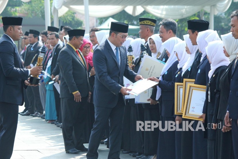 Gubernur Jawa Barat Ridwan Kamil memberikan penghargaan kepada sejumlah guru berprestasi saat upacara Peringatan Hari Guru Nasional Tingkat Provinsi Jawa Barat, di lapangan Gasibu, Kota Bandung, Senin (25/11).