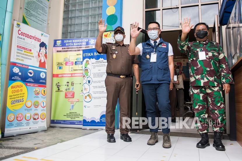 Gubernur Jawa Barat Ridwan Kamil (tengah) bersama Pangdam III Siliwangi Mayjen TNI Nugroho Budi Wiryanto (kanan) dan Kepala Kejati Jabar Ade Adhyaksa (kiri) berjalan keluar gedung seusai menjalani pemeriksaan kesehatan di Puskesmas Garuda, Kecamatan Andir, Bandung, Jawa Barat, Senin (14/12/2020). Ridwan Kamil menjalani uji klinis tahap akhir berupa pemeriksaan darah dalam rangkaian uji klinis tahap III vaksin COVID-19 Sinovac.