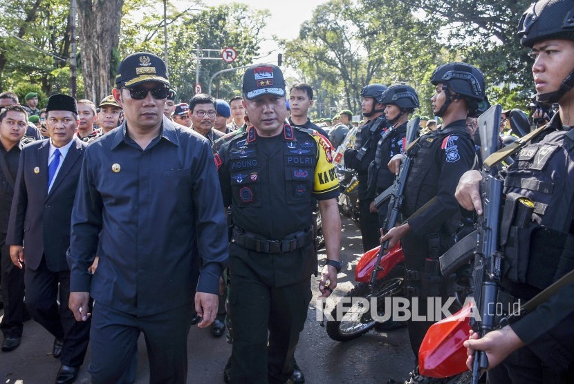 Gubernur Jawa Barat Ridwan Kamil (tengah) didampingi Kapolda Jawa Barat Irjen Pol Agung Budi Maryoto (kanan) dan Walikota Bandung Oded M Danial (kiri) meninjau pasukan seusai Apel Gelar Pasukan dalam rangka Pengamanan Pemilu 2019 di Lapangan Gasibu, Kota Bandung, Jumat (22/3). 