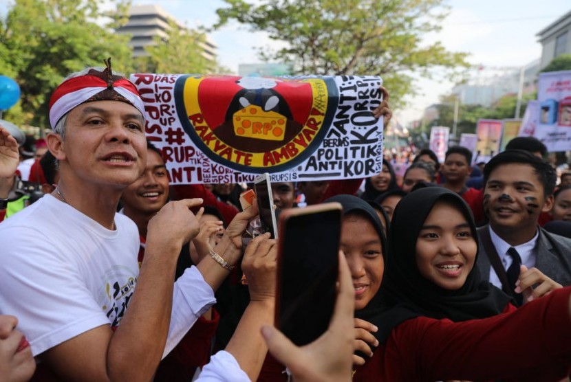 Gubernur Jawa Tengah, Ganjar Pranowo berada di tengah- tengah pelajar, saat memimpin aksi menyuarakan antikorupsi di tengah aktifitas Car Free Day (CFD), di kawasan Simpanglima, Kota Semarang, Ahad (8/12). Aksi ini digelar untuk menyambut Hari Antikorupsi Sedunia (Hakordia) 2019.