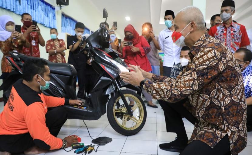  Gubernur Jawa Tengah, Ganjar Pranowo, berdialog dengan peserta usai membuka kegiatan Pelatihan Mekanik Sepeda Motor bagi penyandang disabilitas di SMKN Jateng, di Semarang, Rabu (9/3/2022). Pelatihan keterampilan ini merupakan program kerja sama Banzas Provinsi Jateng dengan SMKN Jateng.