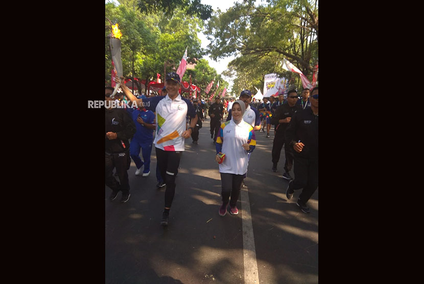 Gubernur Jawa Tengah Ganjar Pranowo dan Istri ikut partai menjadi pembawa obor Asian Games dalam Torch Relay Asian Games di Solo Jawa Tengah, Kamis (19/7). 