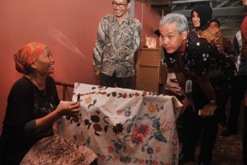 Gubernur Jawa Tengah Ganjar Pranowo (kanan) berdialog dengan perajin di salah satu pabrik batik di Kelurahan Poncol, Pekalongan, Jawa Tengah, Rabu (23/9).
