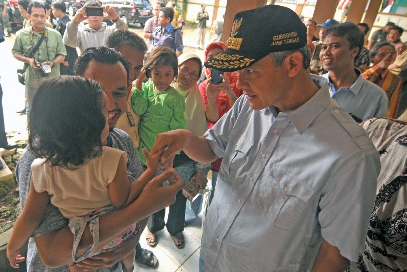 Gubernur Jawa Tengah, Ganjar Pranowo (kanan) menyapa warga saat meninjau TPS 01 di Desa Kembangbaru, Brebes, Jawa Tengah, Rabu (15/2). 