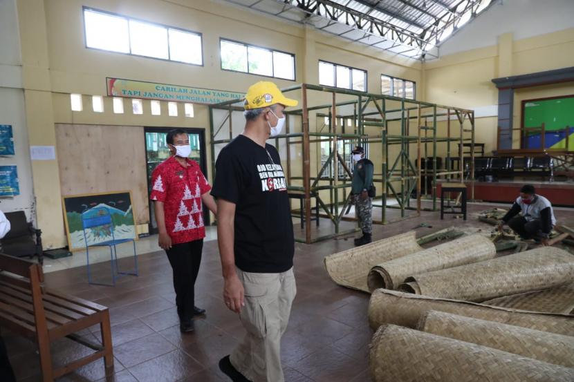 Gubernur Jawa Tengah, Ganjar Pranowo melihat proses penyiapan ruang karantina darurat di Desa Lerep, Kecamatan Ungaran Barat, Kabupaten Semarang, Rabu (8/4). Desa ini menyiapkan 74 ruang karantina darurat guan mengantisipasi warganya yang nekat mudik saat wabah Covid-19.