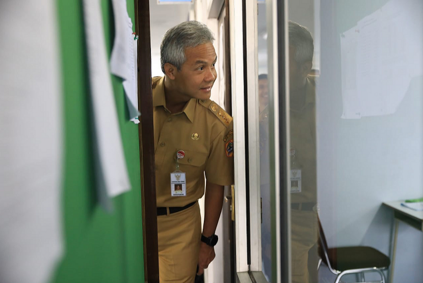 Gubernur Jawa Tengah, Ganjar Pranowo mengintip salah satu ruangan pelaksanaan UNBK di SMK Jatrng, Semarang, Senin (25/3). Gubernur memastikan haribpertama  pelaksanaan UNBK1 jenjang SMK aman dari kendala teknis. 