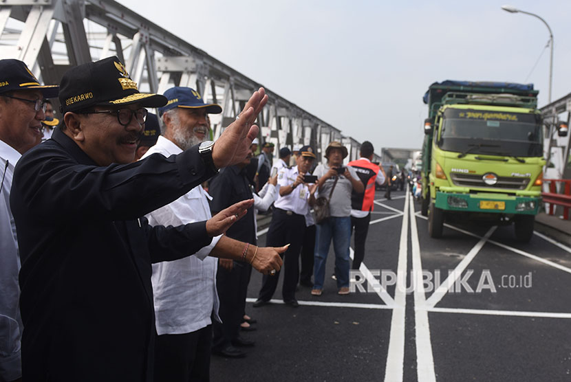 Gubernur Jawa Timur Soekarwo (kiri) menyapa pengendara yang melintasi Jembatan Widang ketika meninjau jembatan tersebut, Tuban, Jawa Timur, Rabu (6/6).
