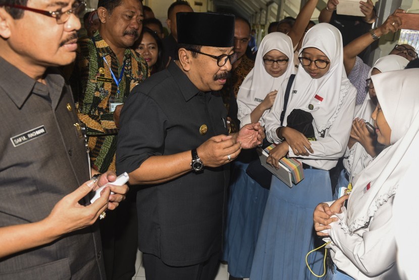 Gubernur Jawa Timur Soekarwo (tengah) berdoa bersama siswa yang akan mengikuti Ujian Nasional Berbasis Komputer (UNBK) saat sidak UNBK di SMAN 5 Surabaya, Jawa Timur, Senin (10/4).