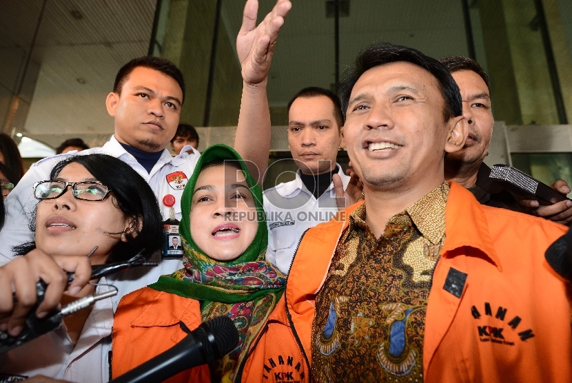 Gubernur Non Aktif Sumatera Utara Gatot Pujo Nugroho (kanan) bersama Istri Evy SUsanti (kiri) berjalan menuju mobil tahanan setelah menjalani pemeriksaan di Gedung KPK, Jakarta, Selasa (25/8).