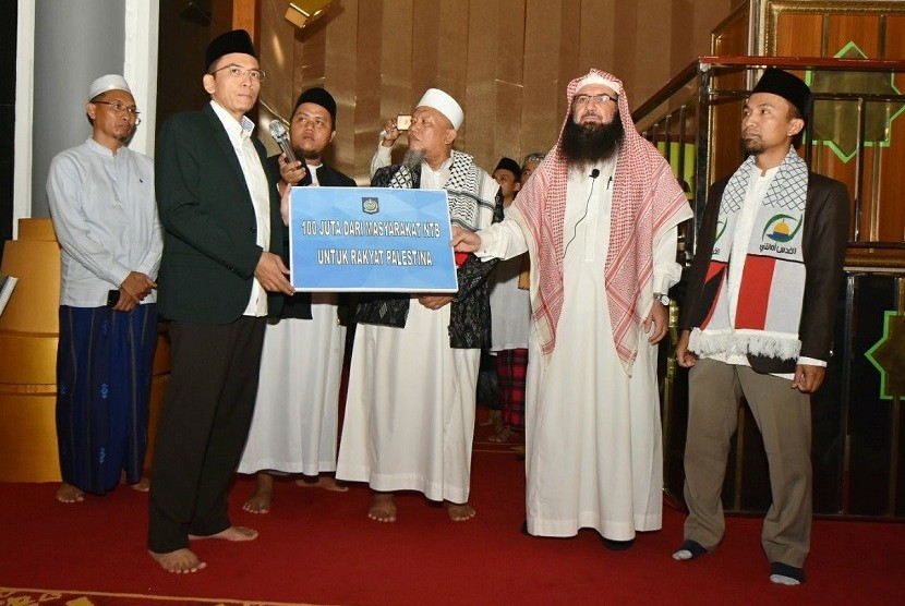 Gubernur NTB TGB Muhammad Zainul Majdi (tengah) menyerahkan bantuan masyarakat NTB untuk Palestina kepada Sekjen Komite Al Quds Ikatan Ulama Internasional Syeikh Dr. Muraweh Mousa Nassar (kanan) usai shalat Jumat di Masjid Hubbul Wathan, Islamic Center NTB, Jumat (16/2) 