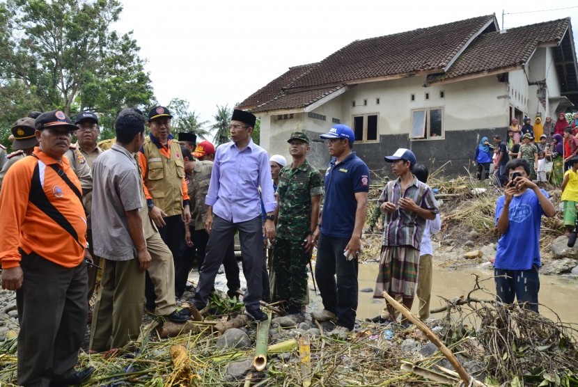 Gubernur NTB TGB Zainul Majdi (tengah) didampingi Kepala BPBD NTB, Muhammad Rum (ketiga kiri) meninjau korban banjir bandang di Desa Senyiur, Keruak, Selong, Lombok Timur, NTB, Selasa (21/11).