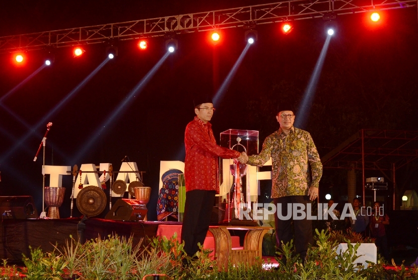  Gubernur Nusa Tenggara Barat (NTB) M. Zainul Majdi (kiri) menerima piala MTQ Nasional dari Menteri Agama Lukman Hakim Saifuddin (kanan) saat malam Ta’aruf yang diadakan di Pendopo Kantor Gubernur NTB, Jumat (29/7) malam.