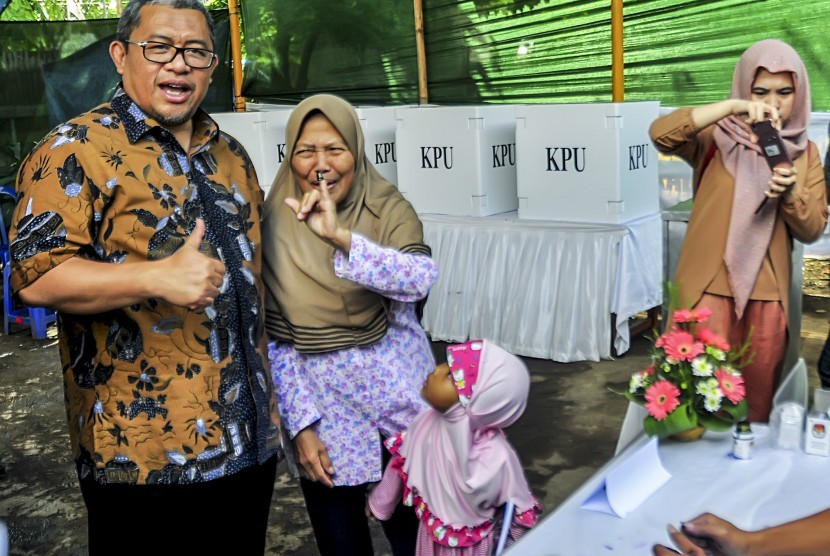 Gubernur Provinsi Jawa Barat, Ahmad Heryawan (kiri) mengapresiasi seorang warga yang telah menggunakan hak suara pada Pilkada serentak 2017 Kota Cimahi di TPS 36 Stasiun, Cimahi, Jawa Barat, Rabu (15/2). 