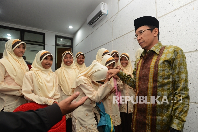 Gubernur Provinsi Nusa Tenggara Barat TGH M. Zainul Majdi (tengah) menyalami siswa saat meninjau pelaksanaan MTQ Nasional ke XXVI di Taman Budaya Kota Mataram, Nusa Tenggara Barat, Rabu (3/8). 