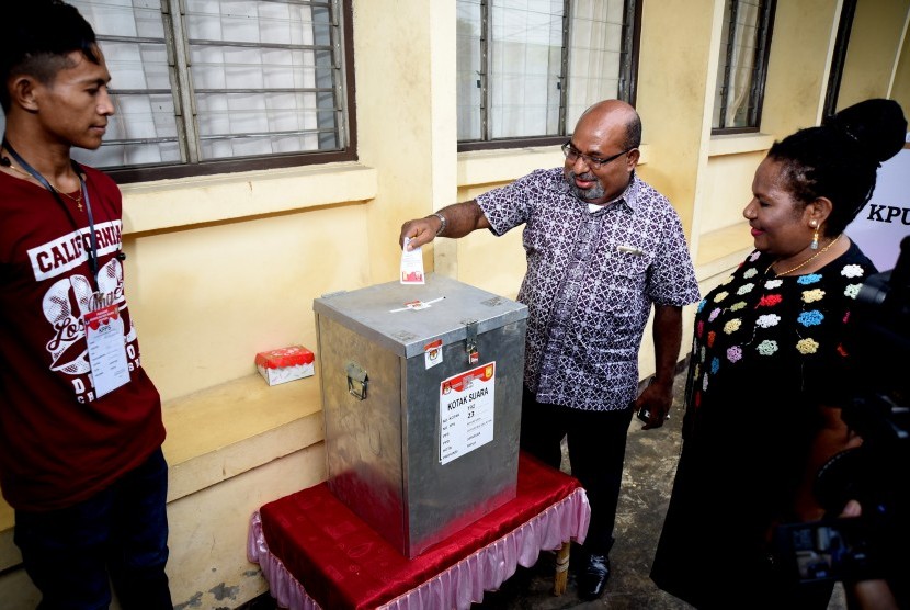 Gubernur Provinsi Papua, Lukas Enembe didampingi istri Yulce Enembe memasukkan surat suara ke kotak suara TPS 23 Jayapura Selatan, Papua, Rabu (15/2).