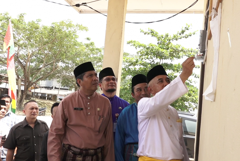 Gubernur Riau Arsyadjuliandi Rachman (kanan) menyalakan MCB di Pos Jaga Pasar Kuala Gasib, Kabupaten Siak Sri Indrapura, Jumat (27/10). 