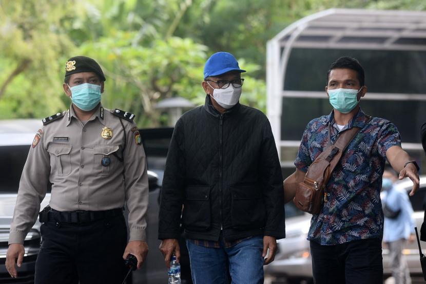 Gubernur Sulawesi Selatan Nurdin Abdullah (mengenakan topi biru) dikawal petugas saat tiba di Gedung KPK, Jakarta, Sabtu (27/2).