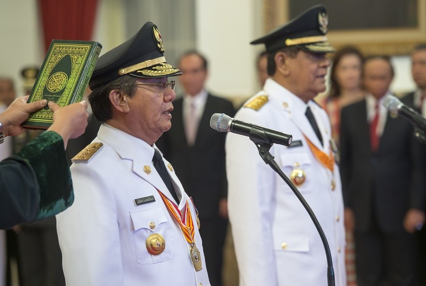 Gubernur Sulawesi Tengah terpilih Longki Djanggola (kiri) dan Wakil Gubernur Sulawesi Tengah terpilih Sudarto (kanan) mengucapkan sumpah jabatan yang dipimpin Presiden Joko Widodo di Istana Negara, Jakarta, Kamis (16/6).