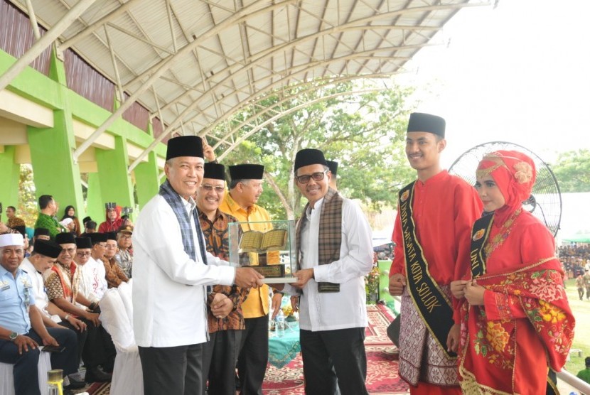 Gubernur Sumatera Barat Irwan Prayitno menyerahkan trofi  MTQ Nasional Tingkat Sumbar edisi 38 kepada juara umum Kabupaten Tanah Datar yang diterima Bupati Irdinansyah Tarmizi di Kota Solok, Jumat (21/6).
