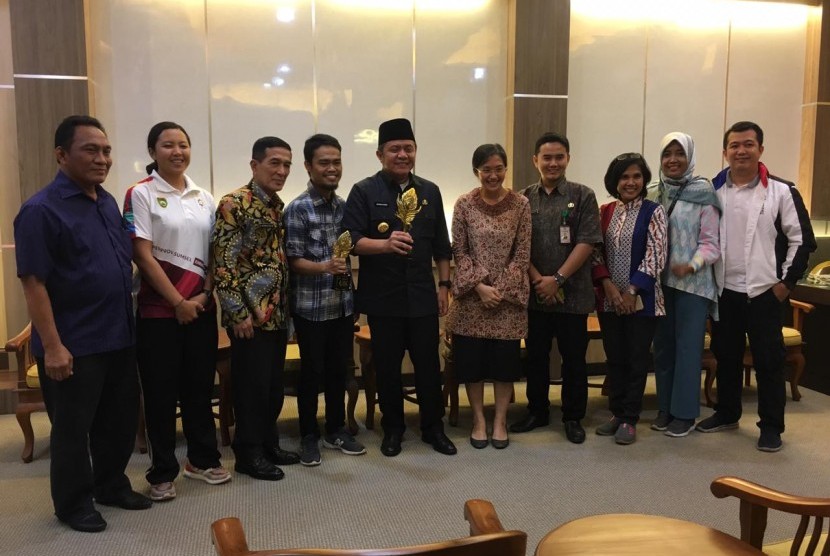 Gubernur Sumatera Selatan (Sumsel) Herman Deru memegang piala juara umum Anugerah Pesona Indonesia (API) 2018 yang diserahkan Kepala Dinas Kebudayaan dan Pariwisata Sumatera Selatan Irene Camelyn bersama tim Disbudpar Sumsel, Jumat (23/11) di ruang tamu Gubernur Sumsel.  