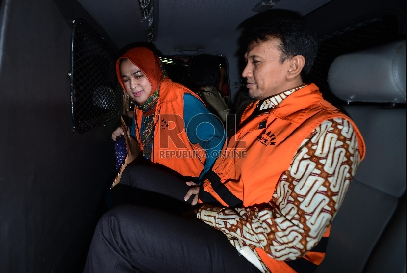Gubernur Sumatera Utara (nonaktif) Gatot Pujo Nugroho bersama bersama istrinya mudanya Evi Susanti, memasuki mobil tahanan usai menjalani pemeriksaan di gedung KPK, Jakarta, Kamis (20/8). 