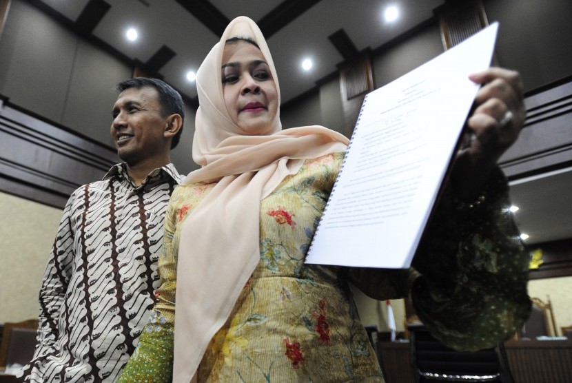 Gubernur Sumatera Utara nonaktif Gatot Pujo Nugroho (kiri) dan istri Evy Susanti (kanan) memperlihatkan naskah nota pembelaan (pledoi) usai mengikuti sidang lanjutan di Pengadilan Tipikor, Jakarta, Rabu (24/2)