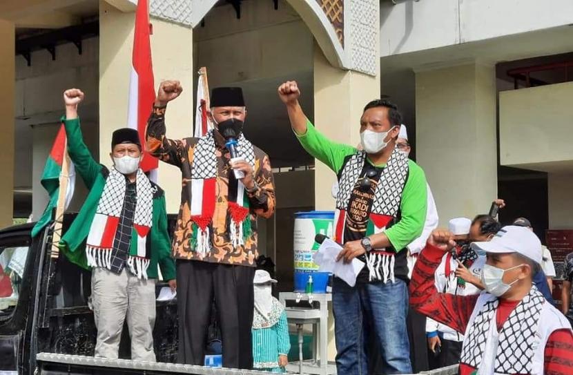 Gubernur Sumbar Mahyeldi Ansharullah memberikan dukungan dengan mengibarkan bendera Indonesia dan Palestina sekaligus melepas ratusan peserta aksi solidaritas Palestina, di halaman masjid Raya Sumatera Barat, Minggu (22/5).