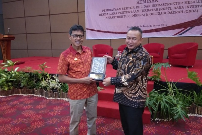 Gubernur Sumbar menerima plakat dari OJK usai memberikan pidato di seminar Pembiayaan sektor riil dan infrastruktur Melalui RDPT, Dinfra dan Oblgasi Daerah' di Hotel Grand Inna Padang, Kamis (21/3).