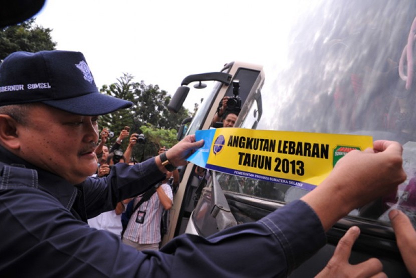 Gubernur Sumsel Alex Noerdin menempelkan stiker angkutan lebaran usai gelar pasukan angkutan lebaran di Terminal Alang-alang Lebar, Palembang, Sumsel, Rabu (31/7).