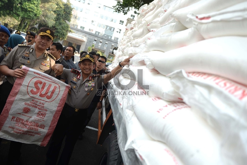 Gula Rafinasi Sitaan. Petugas memeriksa gula rafinasi sitaan di Polda Metro Jaya, Jakarta Pusat, Rabu (24/6).  (Republika/Wihdan)