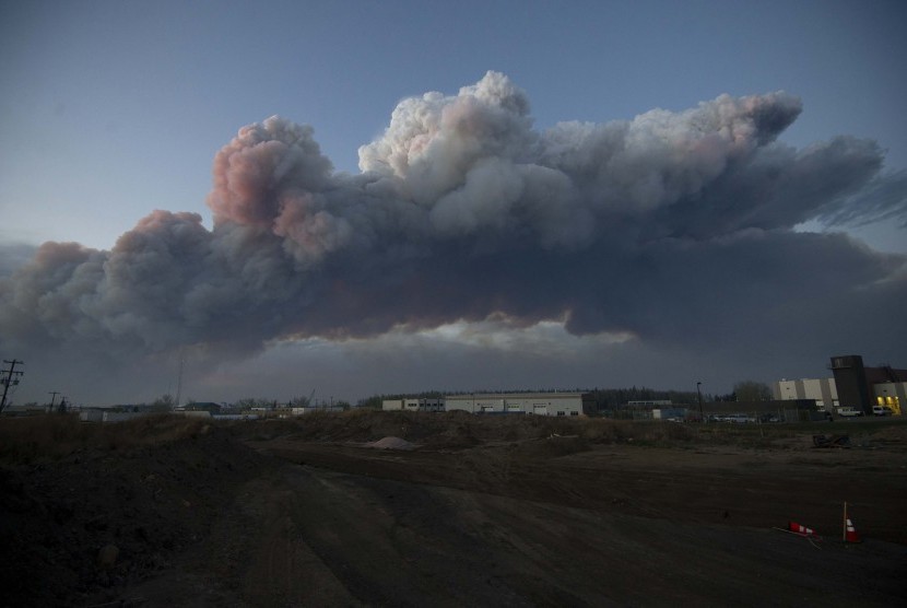 Gumpalan asap hitam kelihatan dari jauh di kawasan terbakarnya lebih dari 100 hektare daerah di Fort McMurray, Alberta, Kanada.